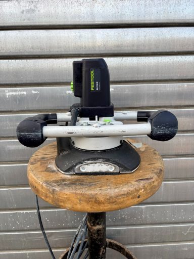 Rundschleifer auf einem Holzblock, mit grüner und schwarzer Elektronik.